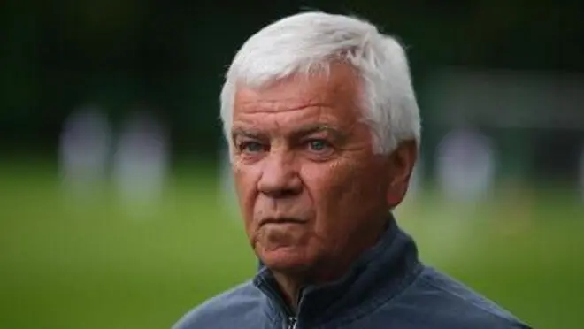 Володимир Мунтян у спортивній синій куртці на зеленомо тлі