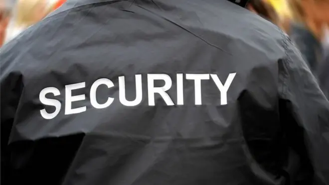 Pesin wey wear jacket wit security ontop.