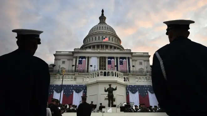 Two members of the Coast Guard Ceremonial Honr Guard watch as members of The President's Own United States Marine Band rehearse.