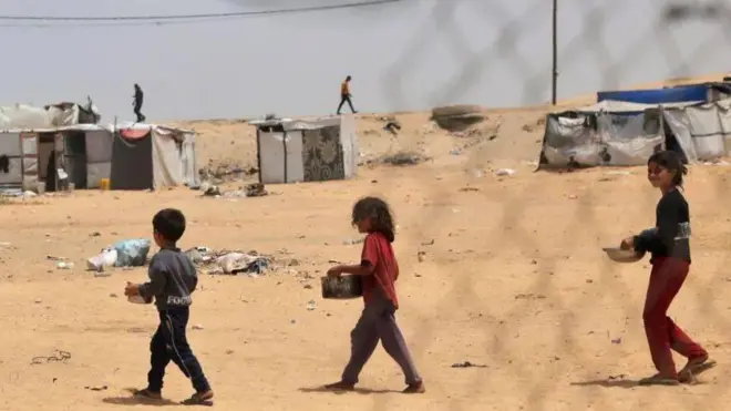 أطفال يحملون معونات غذائية