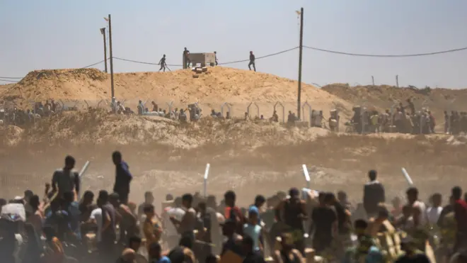 فلسطينيون يتلقون مساعدات من مجموعة مدعومة من الولايات المتحدة في معبر نتساريم بغزة - 29 مايو 2025