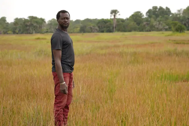 Jean-Louis Mendy devant des champs désaffectés
