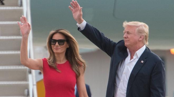Melania y Donald Trump saludando.