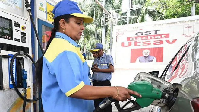 एक पेट्रोल पंप पर गाड़ी में पेट्रोल भरती पंप का कर्मचारी 