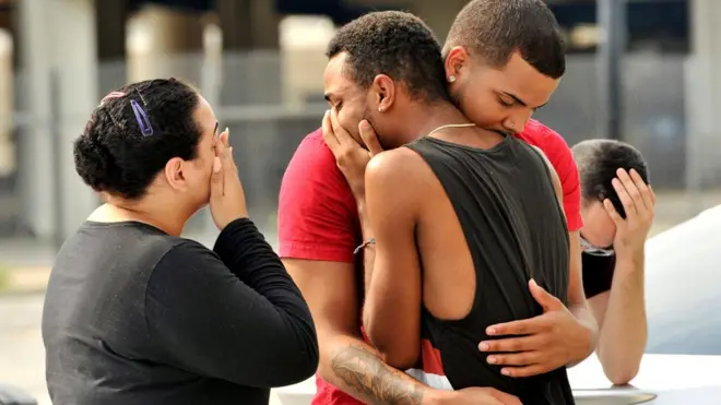 Familiares y amigos de las víctimas de la matanza en el club Pulse, de Orlando, Florida, se congregan frente a la estación de policía que investiga la masacre.