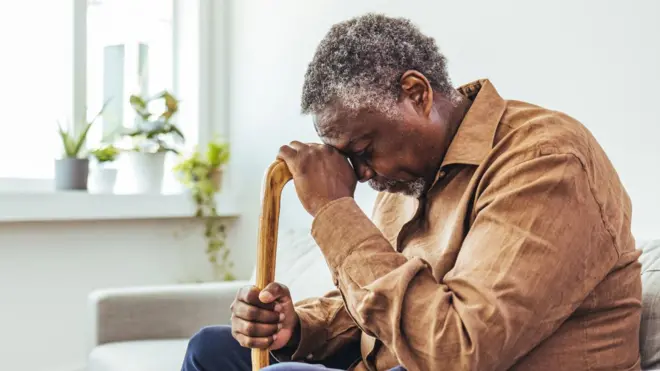 በእድሜ የገፉ ሰው ተቀምተው ምርኩዛቸው ላይ ጭንቅላታቸውን አሳርፈው