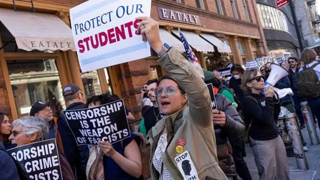 Em protesto contra medidas de Trump, mulher segura cartaz com os dizeres 'Proteja Nossos Estudantes'