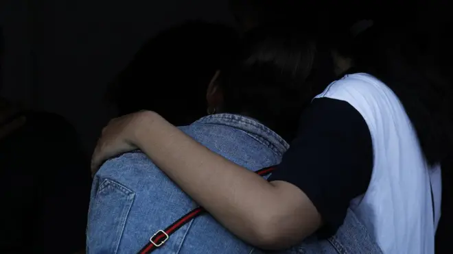 คนหันหลังโอบไหล่กัน