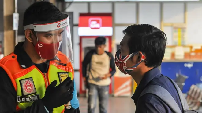 Petugas keamanan menegur calon penumpang Kereta Rel Listrik Commuter Line yang menggunakan masker jenis scuba di Stasiun Bekasi, Jawa Barat.
