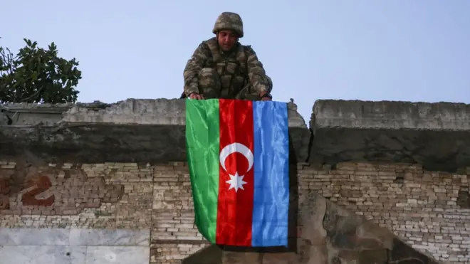 Азербайджанський військовий розміщує прапор на будинку у містечку Джебраїл