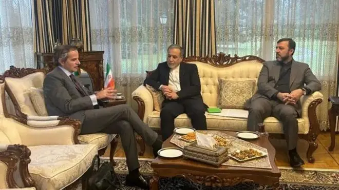 سمت چپ، رافائل گروسی، مدیرکل آژانس بین‌المللی انرژی اتمی در کنار او فرد وسطی عباس عراقچی وزیر خارجه ایران و در سمت راست یک مقام دیگر ایرانی نشسته اند.