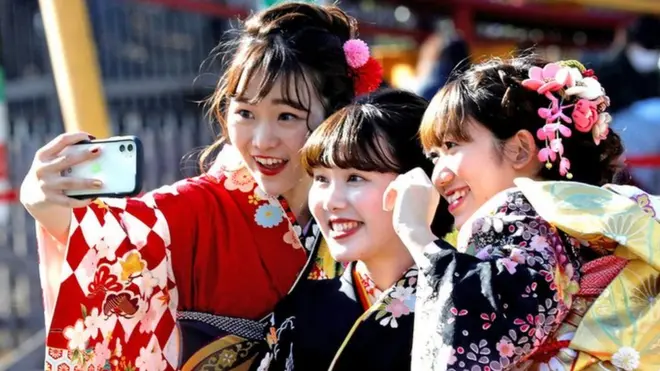 Japanese women wearing kimonos take selfies as they attend their Coming of Age Day celebration ceremony at Toshimaen amusement park in Tokyo, Japan, January 13, 2020.REUTERS/Kim Kyung-Hoon