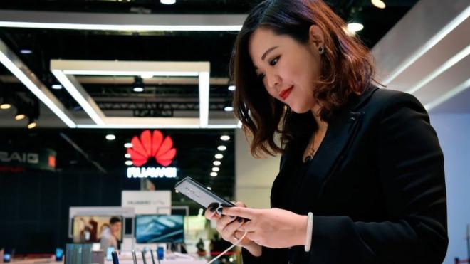 Woman looking at Huawei phone
