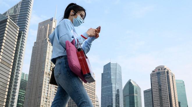 一名戴著口罩的女士走過上海街頭（25/2/2020）