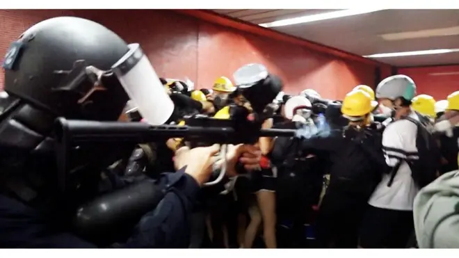 Полицейский стреляет в жителей Гонконга