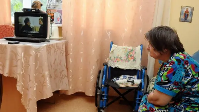 Жінка дивиться телевізор