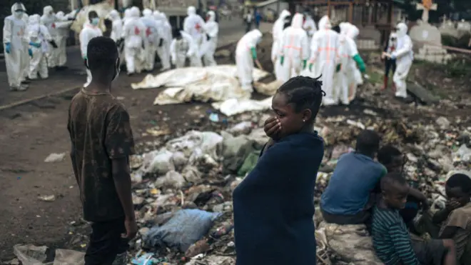 Bamwe mu baturage barimo kureba mu gihe abakozi ba Croix-Rouge barimo guhamba imirambo mu irimbi i Goma ku wa mbere tariki 03 Gashyantare(2) 2025. Ishami rya ONU ry’ubutabazi rivuga ko abantu bagera kuri 900 bapfuye mu mirwano iheruka i Goma