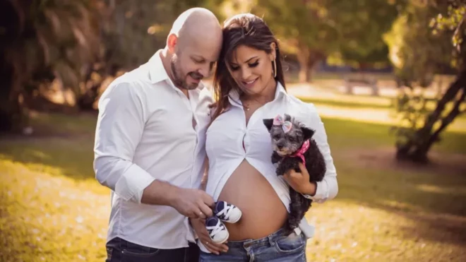 Une femme enceinte et son compagnon qui lui touche le ventre