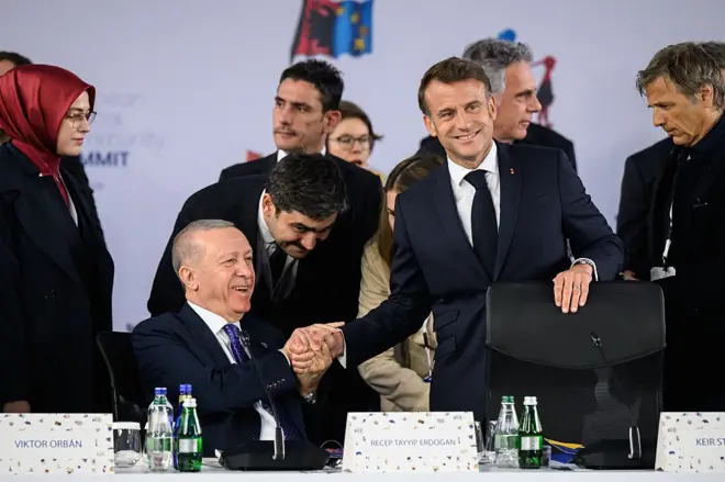 Fransa Cumhurbaşkanı Emmanuel Macron (sağda), 16 Mayıs 2025'te Tiran'da düzenlenen Avrupa Siyasi Topluluğu (APC) zirvesinin genel kurul toplantısına gelirken Türkiye Cumhurbaşkanı Recep Tayyip Erdoğan ile el sıkışıyor.
