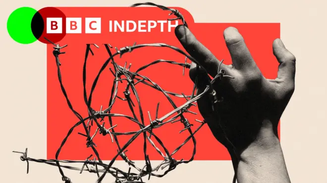 A hand holding barbed wire