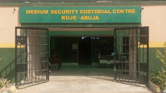 Hoton ƙofar gidan yarin Kuje da ke abuja a buɗe wasu ma'aikata na zaune daga ciki