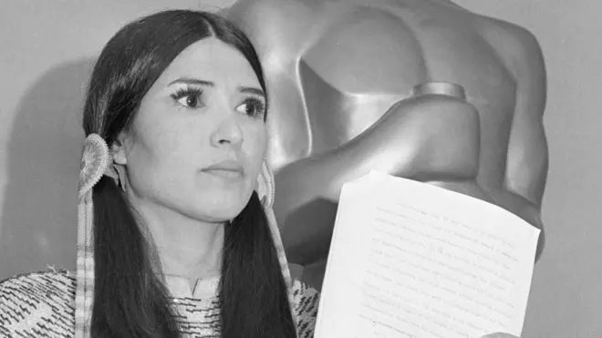 Littlefeather holds Brando's speech in front of an Oscar statue