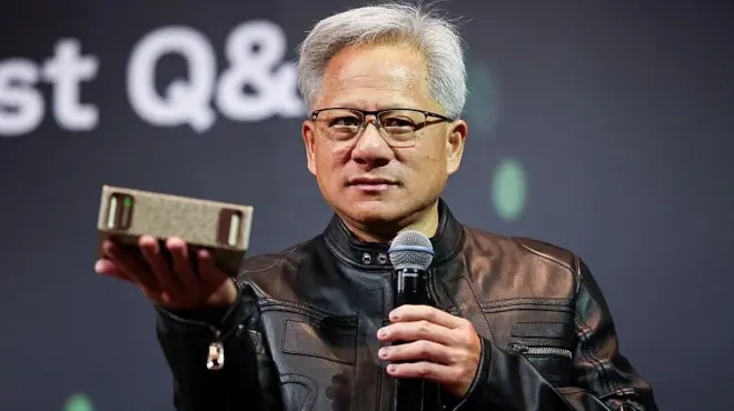 英伟达首席执行官黄仁勋于五月在台北的新闻发布会上发言。照片中他手持一个半导体元件，对观众发表讲话。