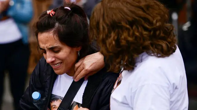 Imagen de dos mujeres que lloran en medio de una manifestación