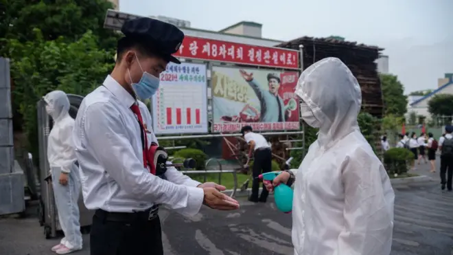 지난해 8월 11일 북한 장철구평양상업대학의 한 학생이 캠퍼스에 들어가기전에 손에 손 소독제를 받고 있다