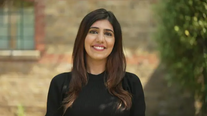 身穿黑色洋裝的洛維娜，她有一頭棕色的頭髮。