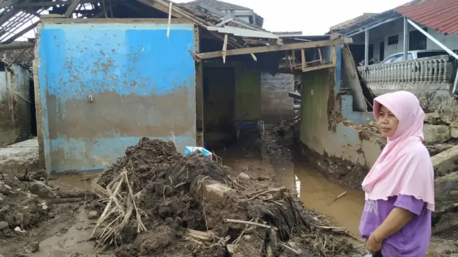 Ibu Egha, Eli Sukenti melihat rumahnya yang rusak diterjang banjir bandang di Kampung Cibuntu, Sukabumi, Kamis (24/09).