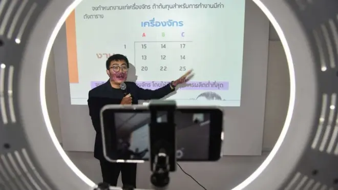 อาจารย์มหาวิทยาลัยกำลังสอนผ่านหน้าจอโทรศัพท์มือถือ ในชั้นเรียนออนไลน์