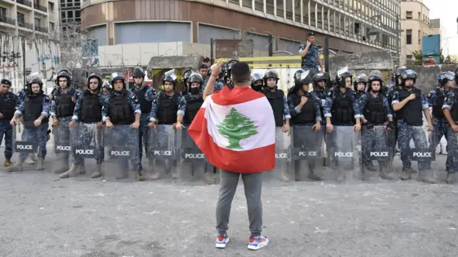 متظاهر يقف أمام القوى الأمنية في العاصمة اللبنانية بيروت، في يوليو/تموز 2020
