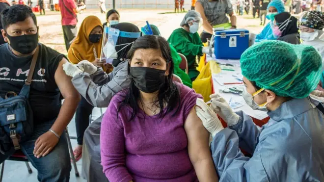Vaksinasi massal di suatu stadion di Surabaya, Jawa Timur.