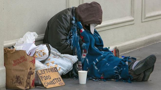 Una persona sin hogar pide dinero en una calle en Estados Unidos.