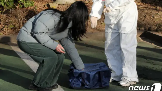 제20대 대통령 선거 사전투표 둘째 날인 5일 오후 제주시 연동 사전투표소인 제주도의회 내 임시 기표소 앞에서 사전투표를 마친 한 신종 코로나 바이러스 감염증(코로나19) 확진자가 바닥에 놓인 가방 안에 투표지를 담고 있다