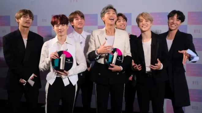 BTS smiling holding awards