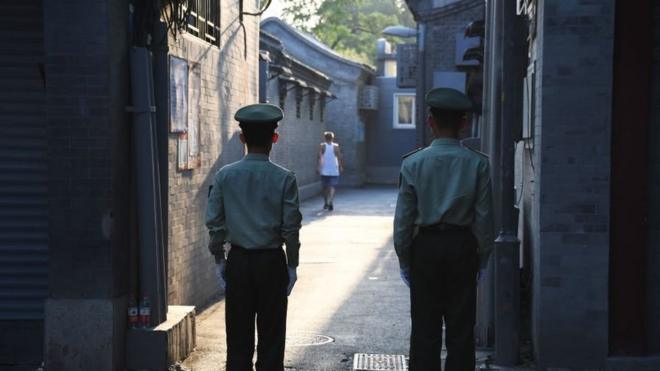 在北京的核心地带，两名警卫正在一条胡同内执勤。