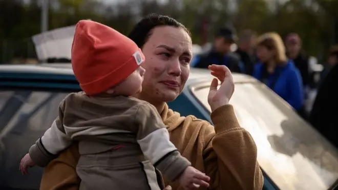Foto ilustrasi: Menggendong anaknya, seorang perempuan tak kuasa menahan tangis setelah tiba dari wilayah yang diduduki Rusia di area pendaftaran dan pemrosesan untuk orang-orang terlantar di Zaporizhzhia, Ukraina, 2 Mei 2022