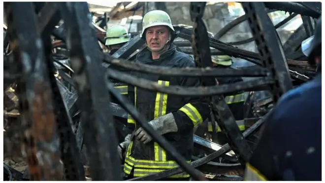 乌克兰消防员正在被空袭毁坏的超市内清理瓦砾。