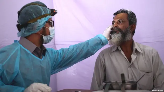 कोरोना वायरस संक्रमण टेस्ट कराता एक शख़्स