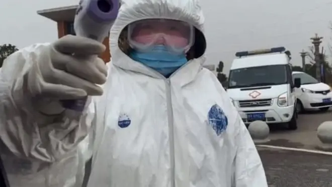 Petugas memeriksa wartawan BBC yang memasuki perbatasan Wuhan.