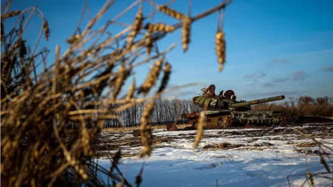 Sebuah tank Rusia yang hancur berada di ladang gandum yang tertutup salju di wilayah Kharkiv, Ukraina.