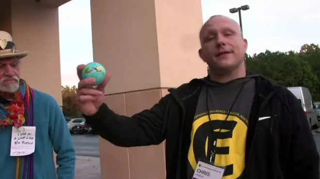 Elinde oyuncak küre tutan bir adam