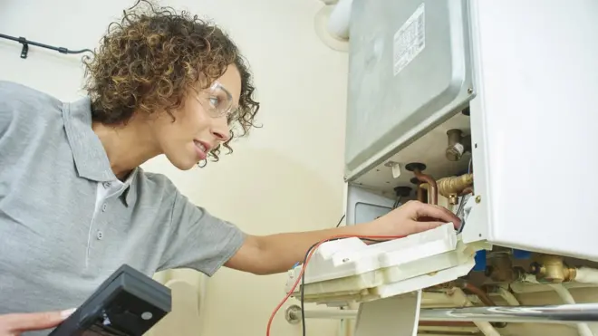 Female engineer inspecting a boiler