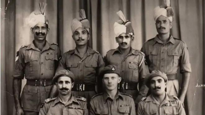 Robin Rowland sits with members of the Punjab regiment for a photo after the Japanese defeat