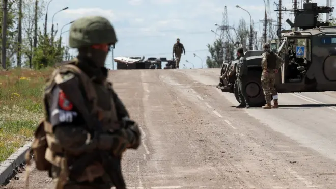 Service members of pro-Russian troops stand guard in Mariupol, Ukraine