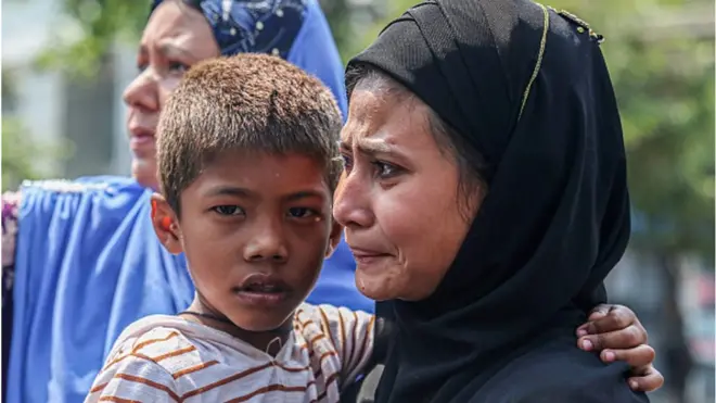 కాల్పుల్లో చనిపోయినవారి అంతక్యియల సందర్భంగా రోదిస్తున్న మహిళ