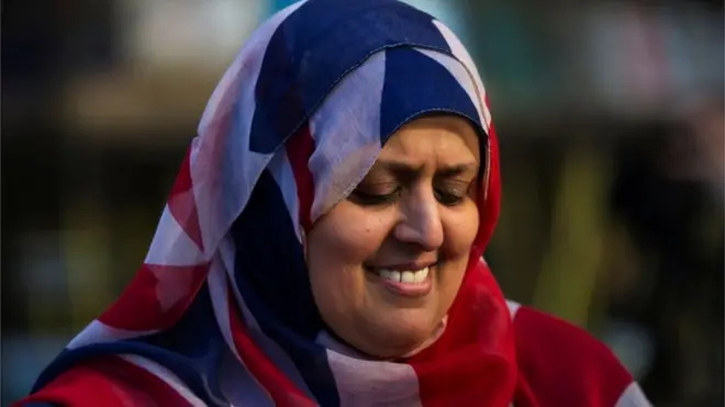 امراة مسلمة تلبس علم بريطانيا غطاء للرأس.