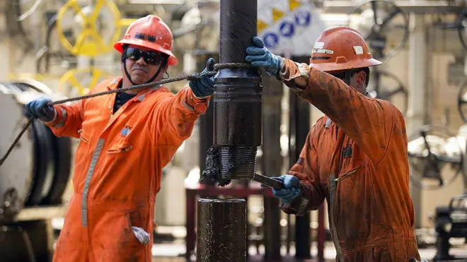 Trabajadores con un mono naranja cambian una tubería de perforación en la plataforma petrolífera Laurus, en la bahía de Campeche
